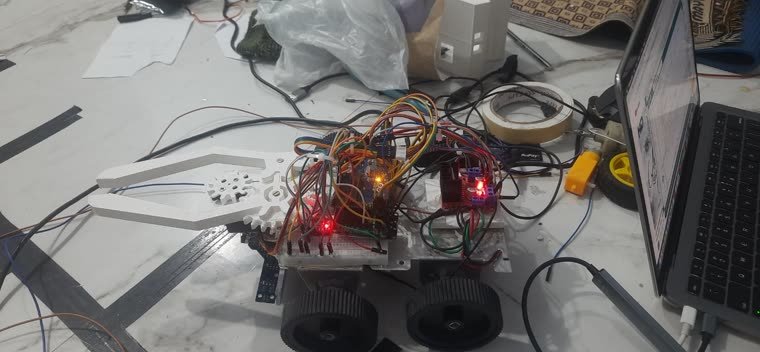 A wheeled robot with a 3D-printed rack-and-pinion gripper and an Arduino on a breadboard